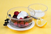 Wild berry salad with goat cheese cream in glass bowl