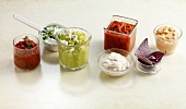Various dips for wraps and tacos on white background
