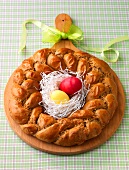 Easter wreath with two eggs in the middle on wooden serving board