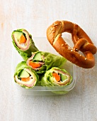 Carrot and cucumber rolls in plastic container, overhead view
