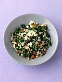 Bowl of green rice with herb and cheese, overhead view