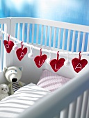 Close-up of baby bed decorated with red hearts
