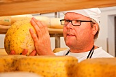 Close-up of man checking cheese on the shelf