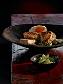 Grilled chicken with coconut marinade, egg and cucumber in bowl