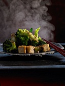 Broccoli with sesame dressing and fried tofu on plate