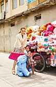 City-Look: Frau und Mädchen, großer Stoffelefant, Plüschtiere auf Wagen