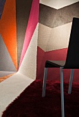 Black chair with multi-coloured patterned carpet