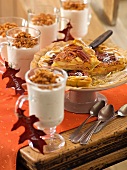 Apple pecan pie on cake stand and glasses with maple syrup cream