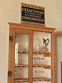 Decanters with wine glass in glass display case