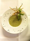 Zucchini soup garnished with herb in bowl