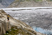 Hiker in front of ice wall in Aletsch Glacier, Marjelesee, Valais, Switzerland