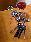 Two corkscrew beside wine glass