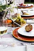 Table setting with wine glasses and halved passion fruit