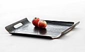 Two apples on black lacquer coated tray