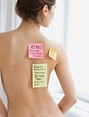 Sticky notes on nude woman's back