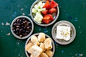 Olives, bread, feta, tomatoes and cucumber on plates
