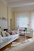 Swedish style living room with white iron bed, wooden table and floor lamp