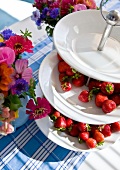 Strawberries on white cake stand with decoration on side