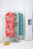 Three red and blue patterned bags on clothes rack