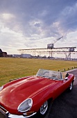 View of Red Jaguar E-type in front of port crane at Holmen, Copenhagen, Denmark