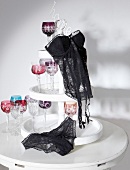 Black transparent lace corset and panties on white �tag�re with wine glasses