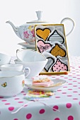Box of heart shaped cookies with tea pot, cup and saucer on table
