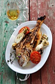 Stuffed sea bream grilled with vegetables on serving dish