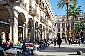 People at tables outside cafes in Placa Reial Square, Barcelona, Catalonia, Spain