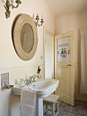 Bathroom with antique sink and wooden mirror in Tuscany, Italy