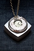 Close-up of pocket watch put dropped in cream