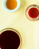 Fish sauce, soy sauce and chili sauce in glass bowl, overhead view