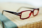 Rote Brille mit braunen Bügeln, close-up