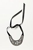 Necklace with black satin ribbons on white background