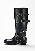 Black rubber boot with studs and buckles on white background