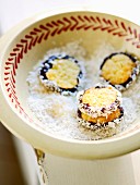 Coconut macaroons in a bowl of grated coconut