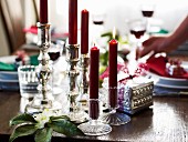 Rote Kerzen in verschiedenen Leuchtern als weihnachtliche Tischdeko