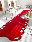 Red felt rug on surface with chairs