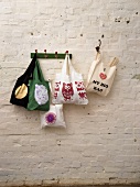 Various bags hanging on rack against white wall