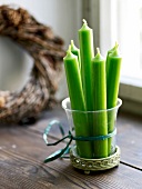 Green candles in glass