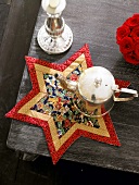 Star shaped table mat with teapot on it