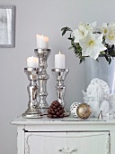 Bauer silver candlesticks with white lid candle and flower on table