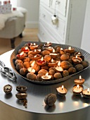Lit candles in walnuts filled with wax in silver tray
