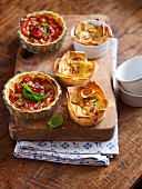 Tomato tartlets and cheesecake with pine nuts on a wooden board