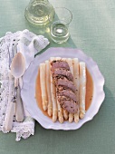 Pork with spice coat filling and white asparagus in serving dish