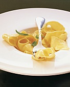 Close-up of homemade egg ribbon pasta with sage on plate 