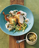 Guinea fowl with vegetables and gooseberry sauce in serving dish