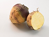 Whole and half turnip on white background