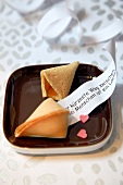 Two fortune cookies on brown plate