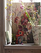 Various flower vase with picture on Frida Kahlo on wooden surface