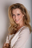 Portrait of pretty blonde woman wearing beige blouse, smiling